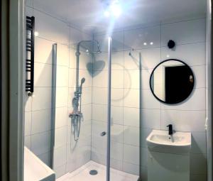 y baño con ducha, lavabo y espejo. en Stanisława Dubois 29, Wrocław, en Wroclaw