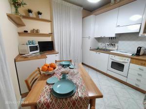 a kitchen with a table with a bowl of oranges on it at Beatrice Apartment con 1camera da letto, un soggiorno cucina e bagno in Scordia