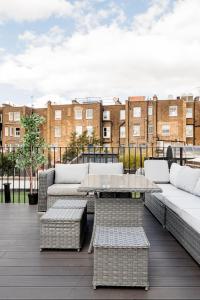 ロンドンにあるSuperb 3 Bed/Bath Luxury + Ibiza Roof Terraceのソファ付きのパティオ、屋上のテーブル