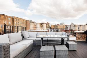 eine Terrasse mit Sofas und einem Tisch auf dem Dach in der Unterkunft Superb 3 Bed/Bath Luxury + Ibiza Roof Terrace in London