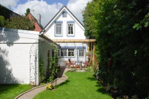 un jardín con una mesa y una casa blanca en Villa-Husum, en Husum