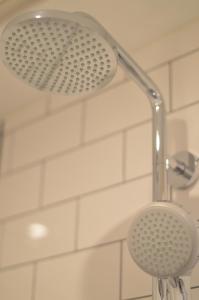 a shower with a shower head in a bathroom at Cosy Casa in Egmond aan Zee