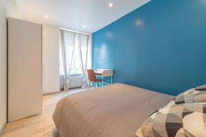een blauwe slaapkamer met een bed en een bureau bij ❂ LES ROCHES ❂ CHIC ❂ CENTRE ❂ 6 PERS. ❂ RDC ❂ RBNB ❂ in Mulhouse