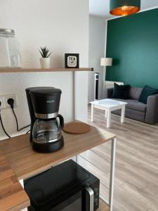 a coffee maker on a table in a living room at Cityapartment in Stadtlohn