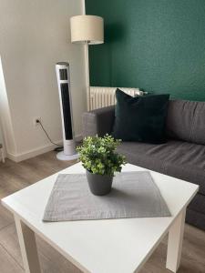een woonkamer met een bank en een tafel met een plant bij Cityapartment in Stadtlohn