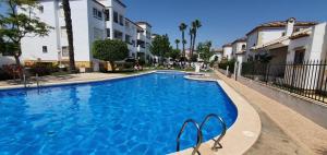 a large blue swimming pool next to some buildings at FABULOUS 2 BED 2 BATH APARTMENT ! in Villamartin