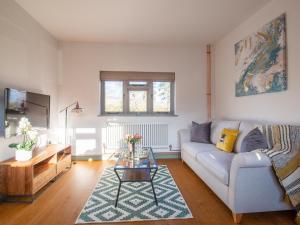 a living room with a couch and a table at Paddock Cottage in Winchcombe