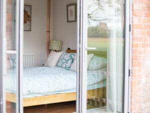 a bedroom with a bed and a window at Paddock Cottage in Winchcombe