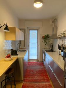 a kitchen with white counters and a red rug at Salasco 20 - Bocconi Porta Romana stylish apt! Self Check- In in Milan