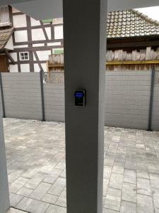 un poste con un reloj al costado de un edificio en L'atypique (prox. Europa park et Rulantica) en Boofzheim