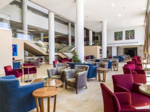a large lobby with chairs and tables and stairs at Olympic Lagoon Resort Paphos in Paphos City