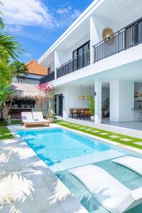 a villa with a swimming pool in front of a house at Villa Dutch in Canggu