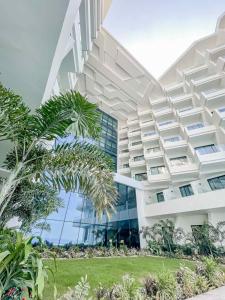 a building with a palm tree in front of it at Lime Resort Manila in Manila