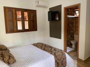 a bedroom with a bed and a tv on the wall at Pousada da Villa in Sao Jorge