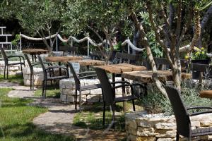 a group of tables and chairs in a park at Ark Beach Apartments next to the beach in Stobrec in Split