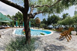 a tree with a ball hanging from it next to a pool at Ark Beach Apartments next to the beach in Stobrec in Split