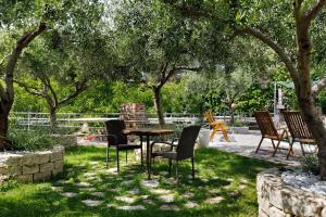 a table and chairs in a yard with trees at Beautiful apartment for 3 adults next to the beach in Split