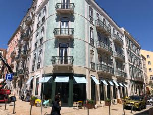 Be Lisbon Hostel Intendente في لشبونة: امرأة تمشي أمام مبنى
