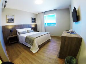 a hotel room with a bed and a television at Marano Hotel in Salvador