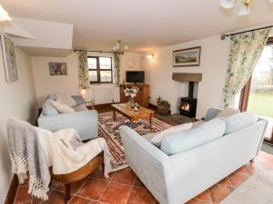 a living room with two couches and a fireplace at Wilstone Cottage in Church Stretton