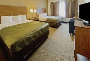 Habitación de hotel con 2 camas y TV de pantalla plana. en Quality Suites University, en El Paso