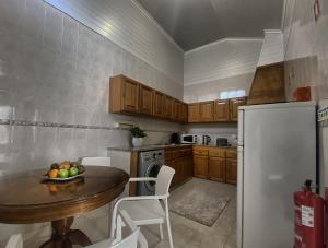 a kitchen with a table and a refrigerator at Além do Mar Apartment - RRAL n. 3214 in Ribeira Grande