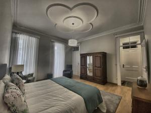 a bedroom with a large bed and a chandelier at Além do Mar Apartment - RRAL n. 3214 in Ribeira Grande