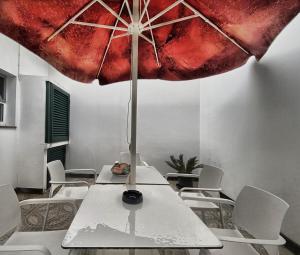 a table with an umbrella on top of it at Além do Mar Apartment - RRAL n. 3214 in Ribeira Grande