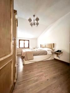 a bedroom with a bed and a chandelier at HOTEL CAMPO STELLA in Leonessa