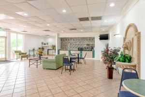 a waiting area with tables and chairs in a waiting room at Rodeway Inn in Huntsville