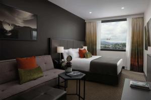 a hotel room with a bed and a couch at Rydges Wellington Airport in Wellington