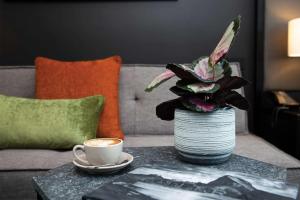 a table with a cup of coffee and a plant at Rydges Wellington Airport in Wellington