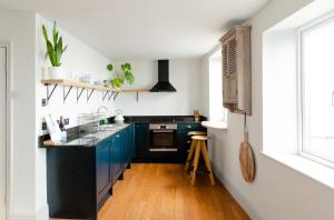 a kitchen with blue cabinets and a black counter top at Star & Garter in Falmouth