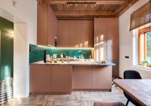 una cocina con armarios marrones y azulejos verdes en Rezydencja Julin Slow Life dla Gości 16+, en Wydrze
