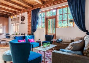 una sala de estar con sillas azules, mesas y ventanas en Rezydencja Julin Slow Life dla Gości 16+, en Wydrze