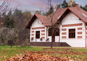 une maison blanche avec un toit rouge dans l'établissement Rezydencja Julin Slow Life dla Gości 16+, à Wydrze