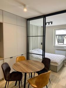 Habitación con mesa, sillas y cama en APARTAMENTY PIANO POLNA 28, en Świeradów-Zdrój