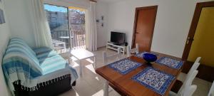a living room with a table and chairs and a balcony at Sa Shei Apartment Tossa de Mar in Tossa de Mar