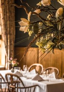 una mesa con mesas y sillas blancas y un arreglo floral en Hotel Bakker en Vorden