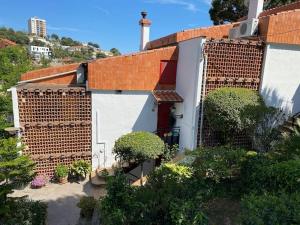 a house with a brick wall and some plants at Canyelles BBQ Apartment in Lloret de Mar