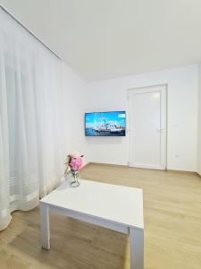 a white table in a white room with a vase of flowers at Apartment Ane 3 in Tisno