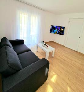a living room with a black couch and a table at Apartment Ane 3 in Tisno