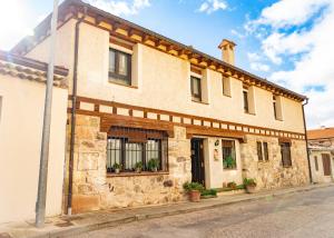 ein altes Steingebäude mit Pflanzen an den Fenstern in der Unterkunft El Pajar de Trescasas in Sonsoto