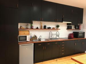 a kitchen with black cabinets and a microwave at Les Roches Blanches in Étretat +5 photos