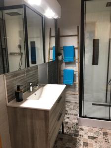 baño con lavabo y ducha con sillas azules en Les Roches Blanches, en Étretat
