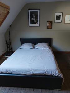 Una cama con sábanas blancas y almohadas en un dormitorio en Gery Art Gallery, en Namur