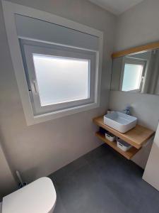 łazienka z białą umywalką i lustrem w obiekcie Apartamentos Angelito Playa América A w mieście Nigrán