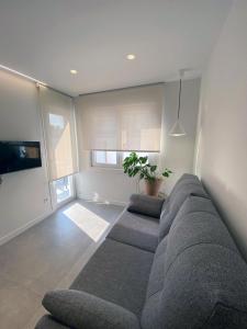 salon z kanapą i telewizorem w obiekcie Apartamentos Angelito Playa América A w mieście Nigrán