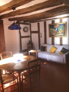 uma sala de estar com uma cama e uma mesa com uma sala de jantar em La Vigne dorée em Saint-Martin-des-Champs