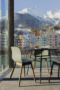 a table and chairs on a balcony with a view at Marktbar Studios - Boutique Aparthotel in Innsbruck